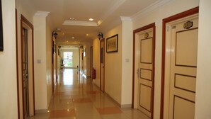 A hotel corridor with doors numbered 203 and 204, a fire extinguisher, and a framed picture on the wall. - Lanvin Hotel (Kota Kinabalu)
