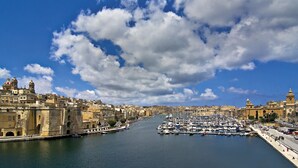 Un puerto con barcos, un edificio histórico y un cielo despejado.