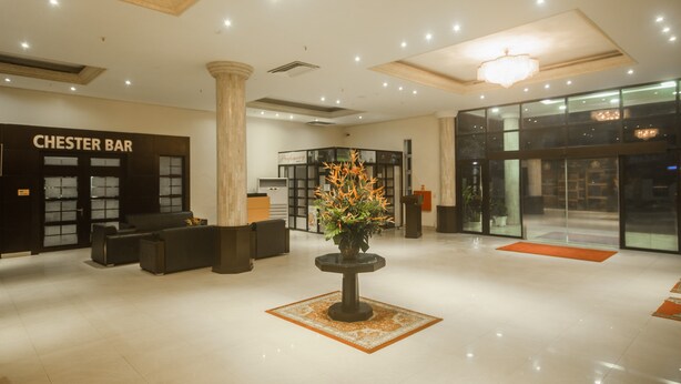 A hotel lobby with a Chester Bar, a reception desk, and a decorative plant. - The Metropolitan Hotel Calabar (Calabar)