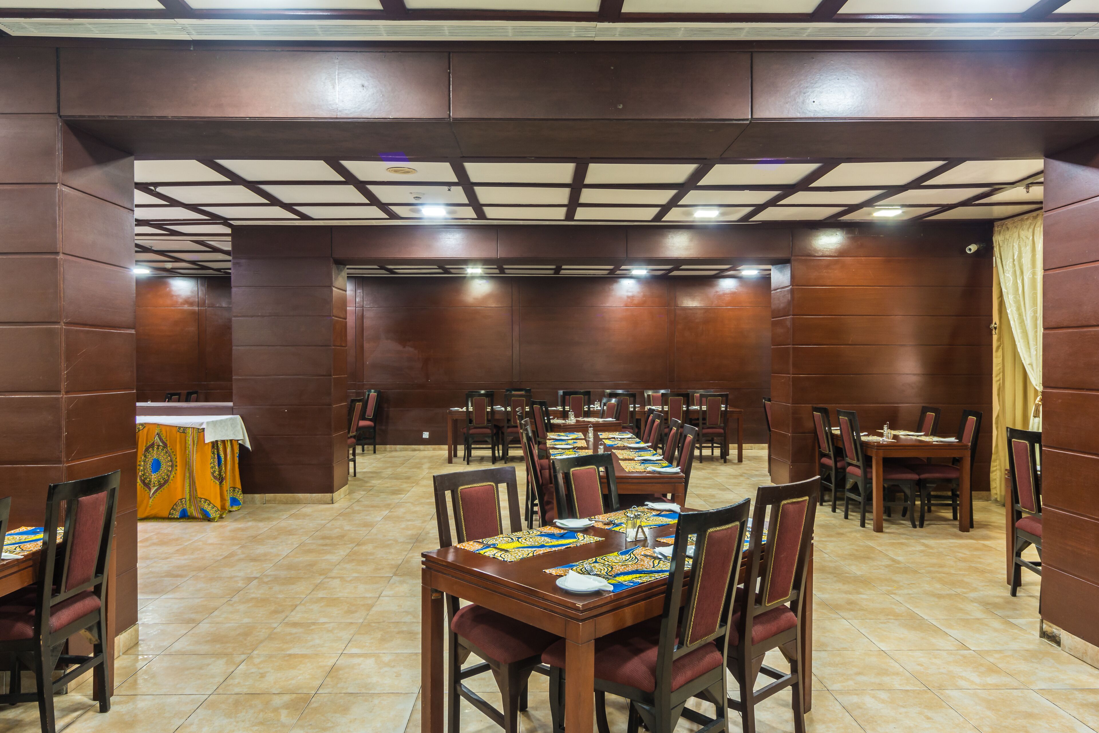 A spacious dining area with multiple tables and chairs, arranged in rows.
