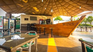 A restaurant with a wooden counter, bar stools, and a glass table. - The Metropolitan Hotel Calabar (Calabar)