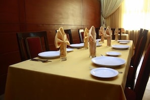Une table à manger dressée avec des assiettes, des couverts et des serviettes.