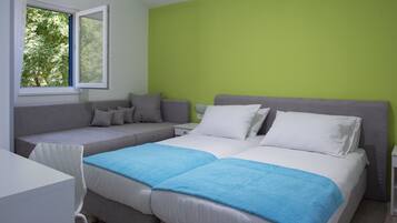 A bedroom with a bed, a sofa, and a window.