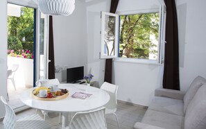 Una habitación moderna con comedor, televisor de pantalla plana y sofá.