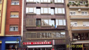 Un immeuble à plusieurs étages, doté d’une façade rouge et de balcons.