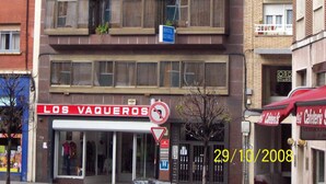 Un immeuble à plusieurs étages, avec une enseigne indiquant « Hostal Alvarez » au deuxième étage.