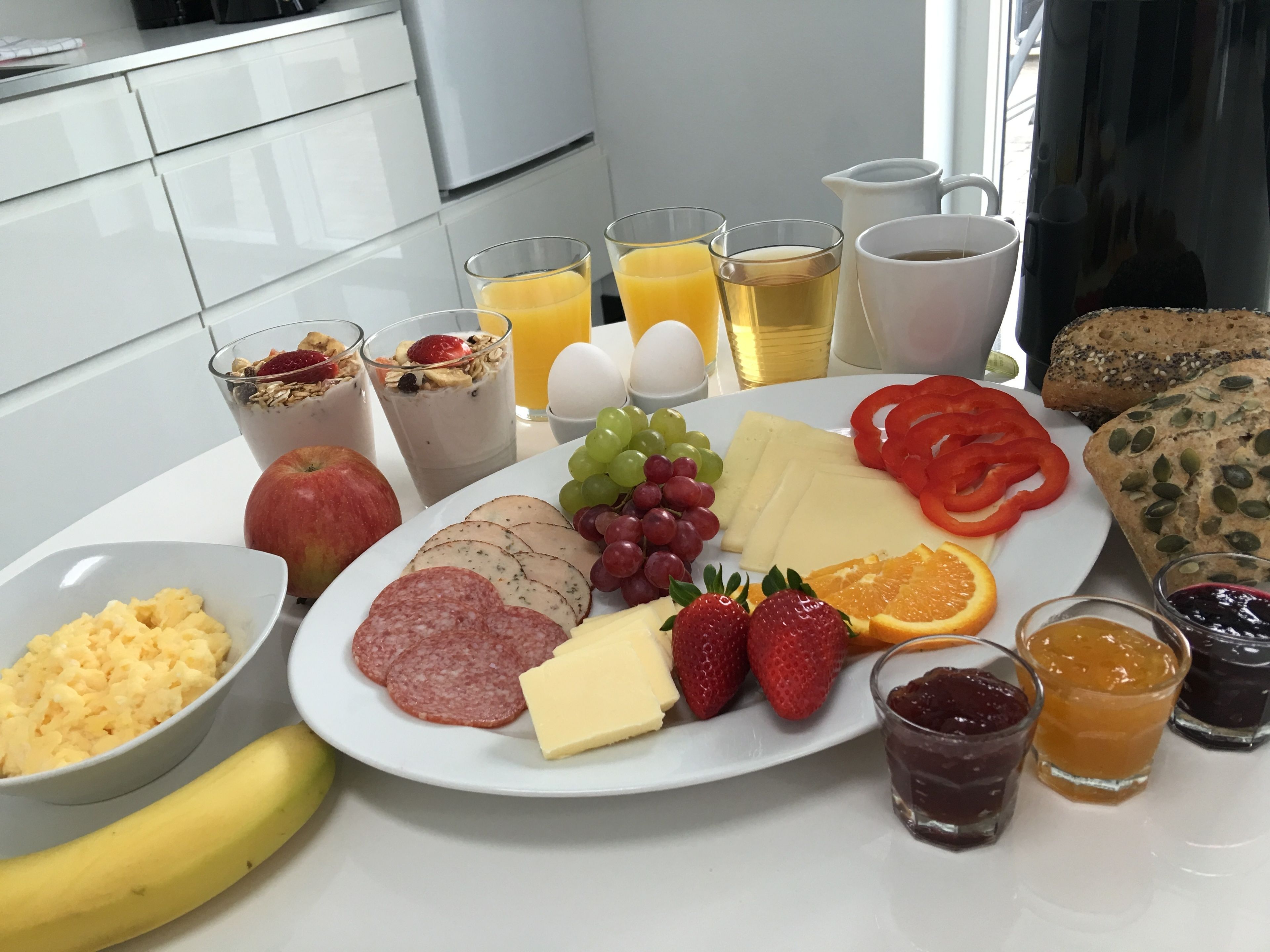 A breakfast spread with various foods and drinks on a table.