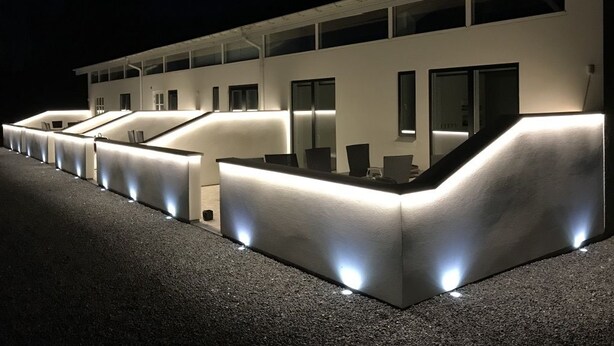 A modern building with a series of reception desks and seating areas, illuminated by underglow lighting. - Elisesminde (Vejle)