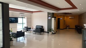 Un moderno vestíbulo con mostrador de recepción, zona de estar y área de comedor.