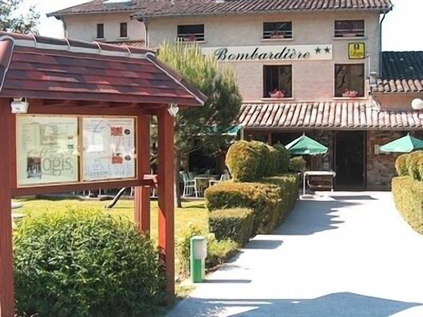 A building with a sign reading "Bombardiere" and a pathway leading to it.