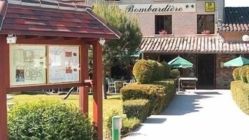 A building with a sign reading "Bombardiere" and a pathway leading to it.