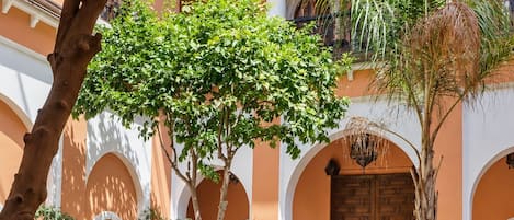 A courtyard with a pool, outdoor seating, and a traditional architectural style.