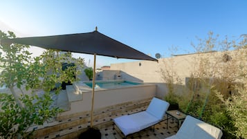 Una piscina al aire libre, sillones reclinables de piscina