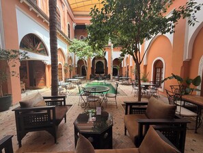 A courtyard with outdoor seating, a pool, and arches. - Riad Amina (Marrakech)