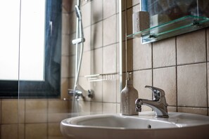 Apartamento, vistas al mar | Baño | Ducha, cabezal de ducha tipo lluvia, secador de pelo y toallas