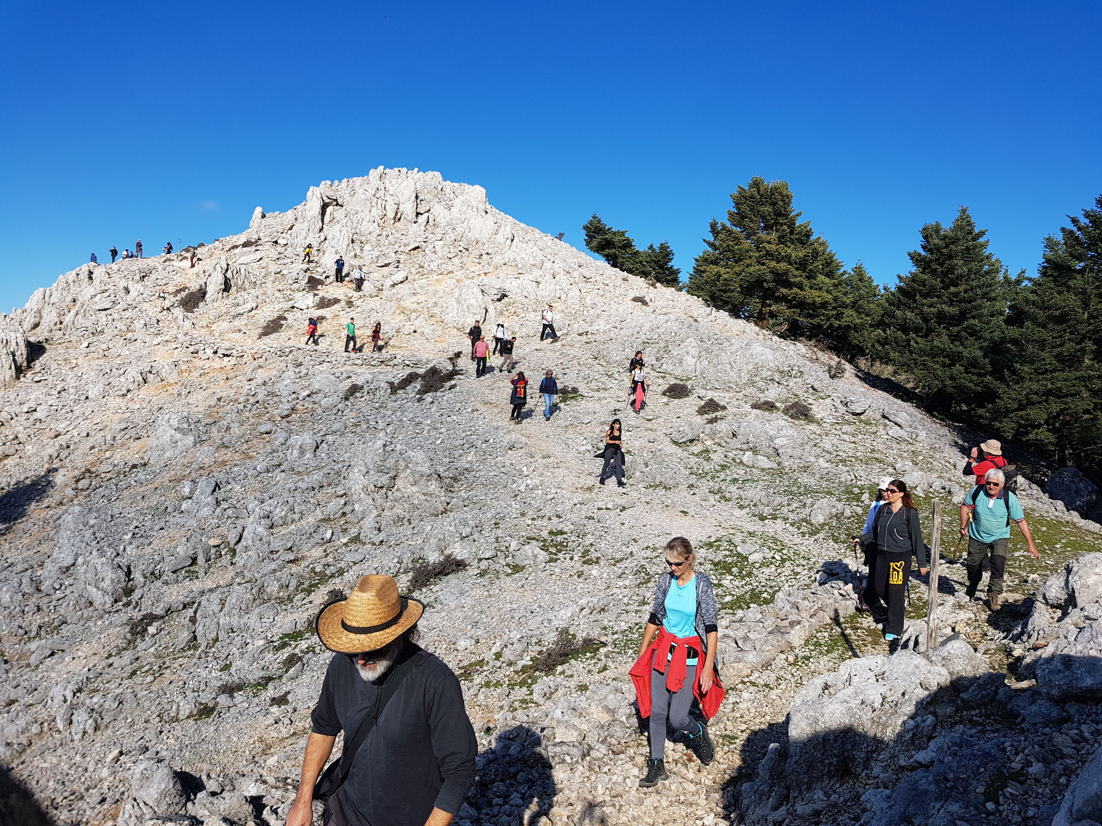 A rocky mountain path with hikers ascending.