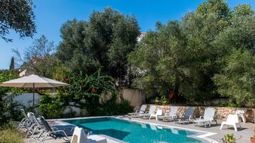 Ein Pool mit Liegestühlen und Topfpflanzen.