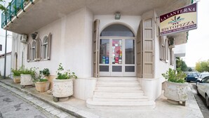 A building with a sign for La Lanterna Ristorante Pizzeria, featuring a set of steps leading to a glass door with multiple windows.