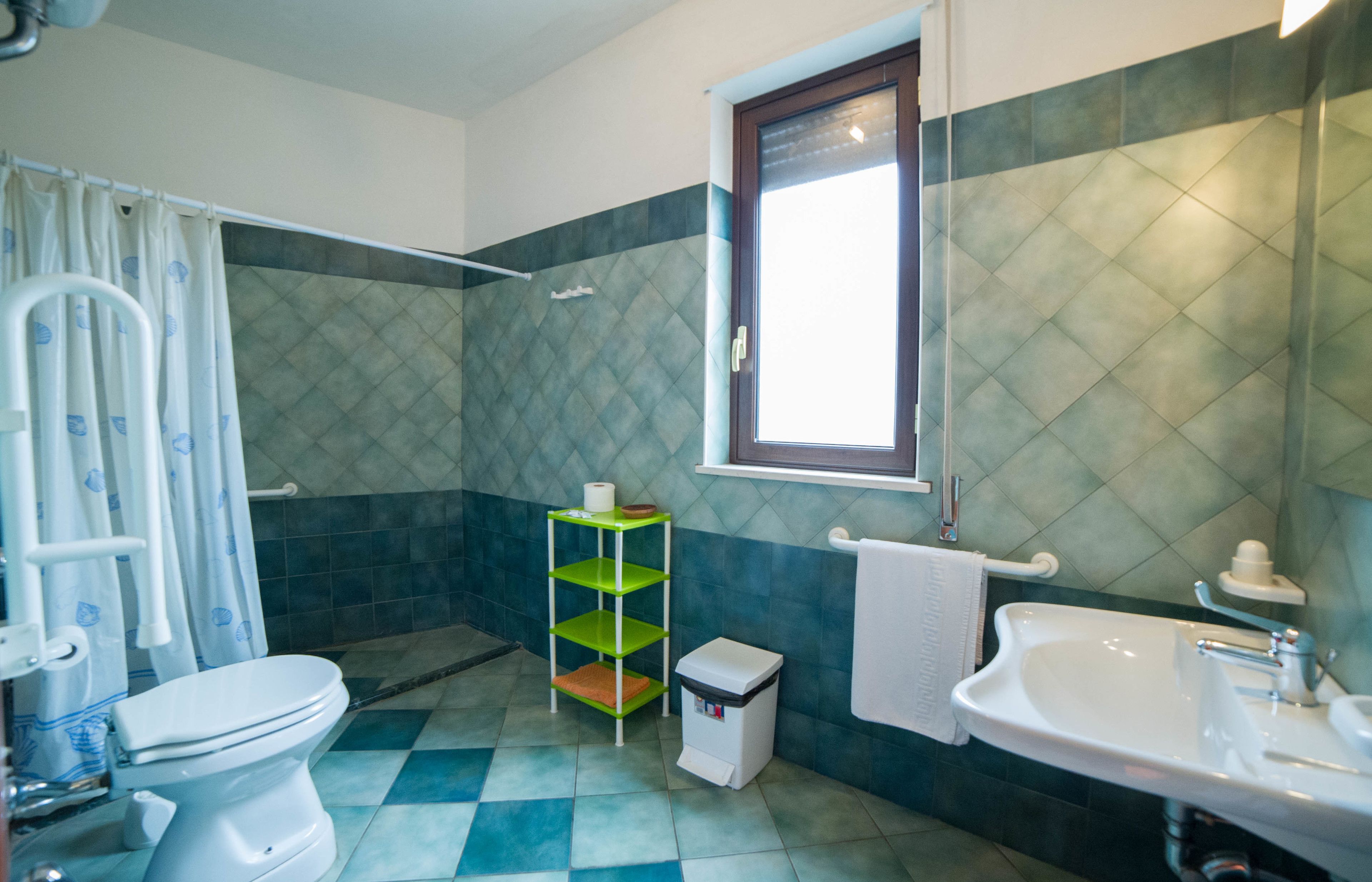 A bathroom with a toilet, sink, and shower area.