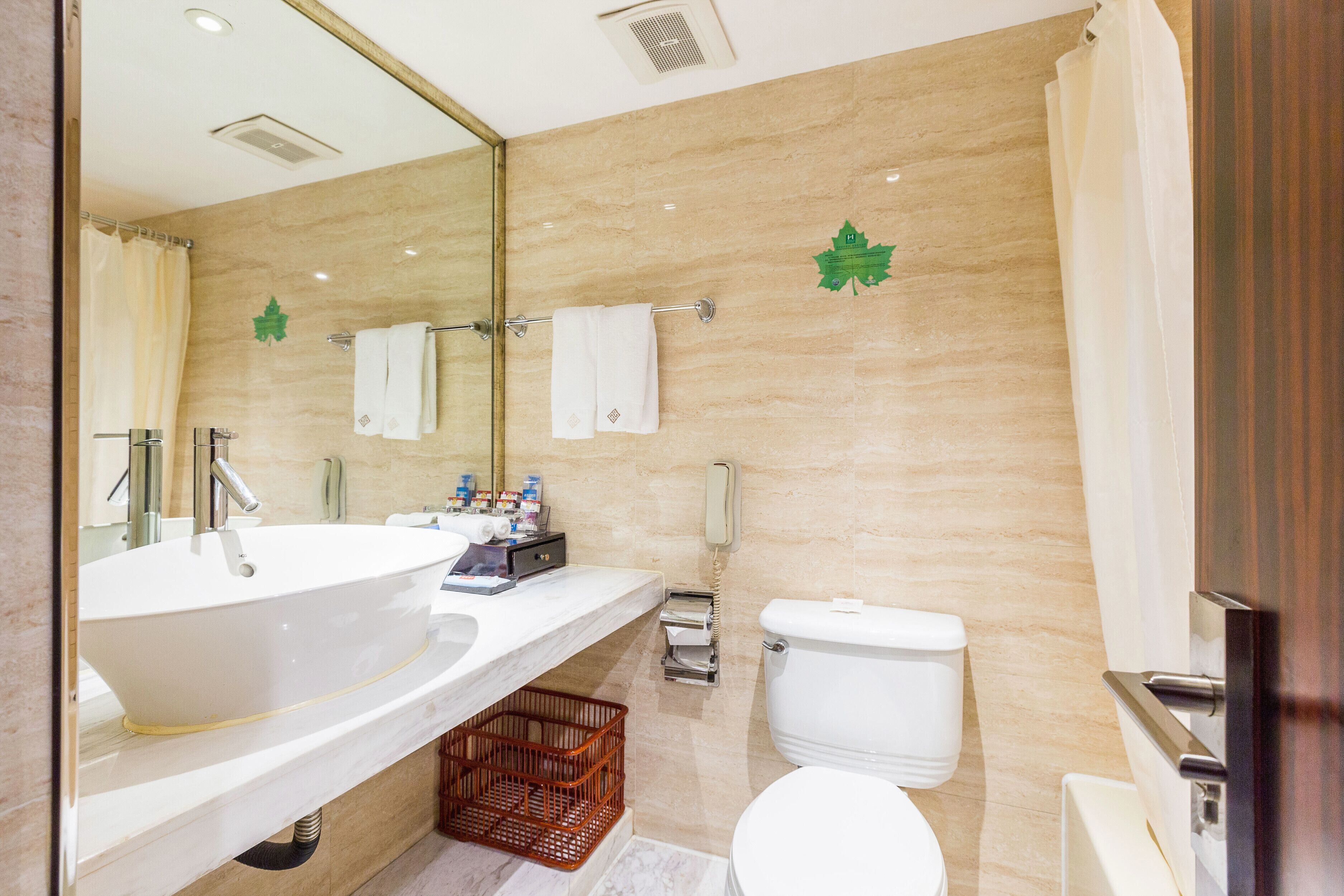 A modern bathroom with a large sink, toilet, and shower.