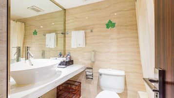 A modern bathroom with a large sink, toilet, and shower.