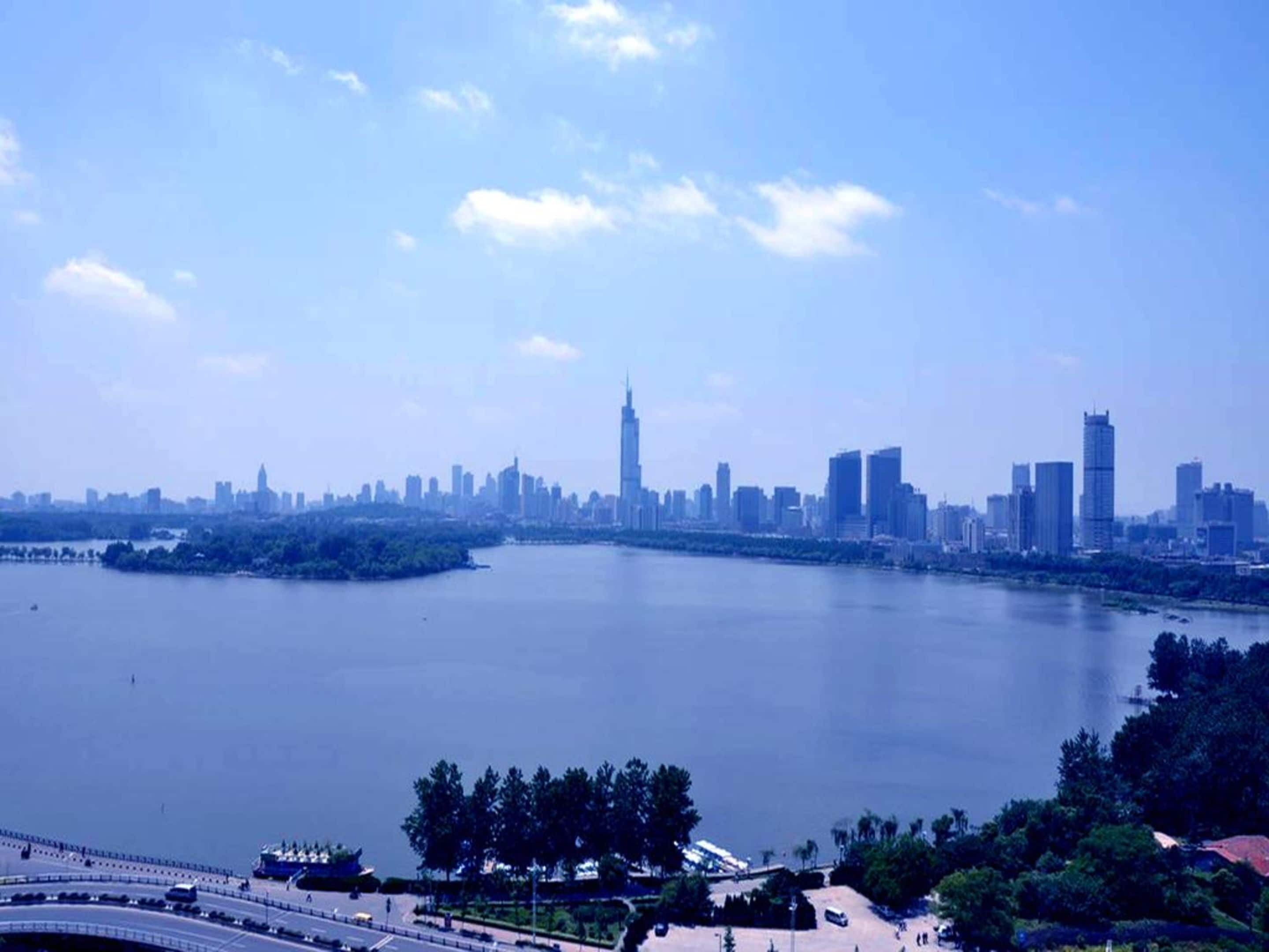 A city skyline with a prominent tower, a river, and a bridge.