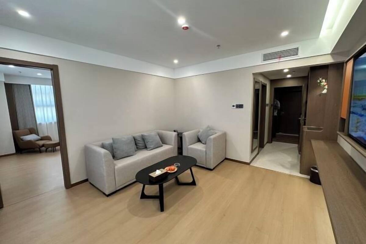 A modern living room with a sofa set, a coffee table, and a TV.