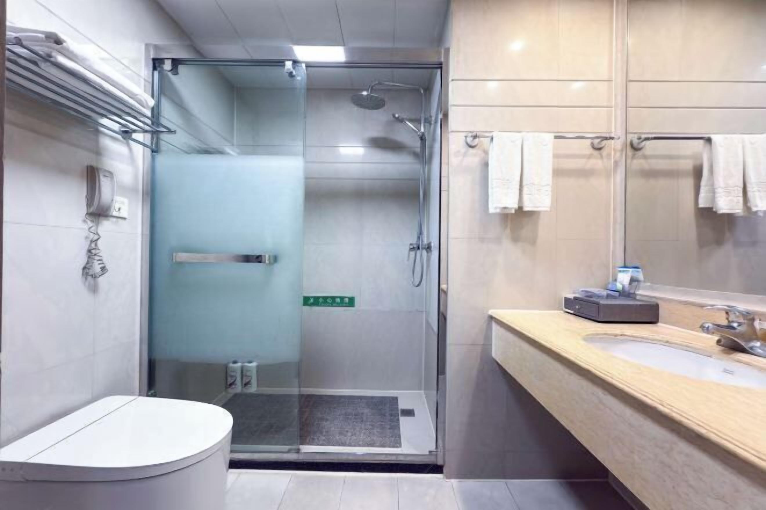 Une salle de bain moderne avec une douche à parois de verre, un lavabo avec un miroir et des toilettes.