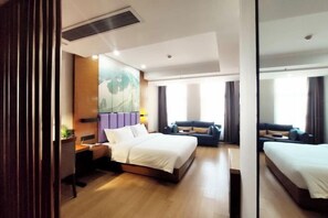 Una habitación de hotel con una cama grande, un escritorio, una silla, un sofá y un espejo amplio.