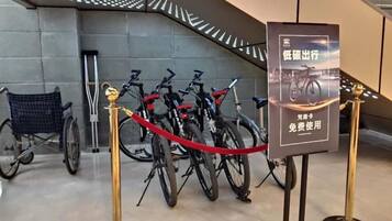 Cyklar parkerade inomhus med en skylt som visar att det finns en cykeluthyrning här.
