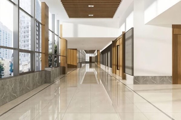 A long, polished corridor with large windows, wooden paneling, and a reflective floor. - Elegance Hotel (Suqian)