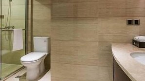 A modern bathroom with a glass shower enclosure, a toilet, and a sink. - Fujian Enjoy Hotel (Fuzhou)