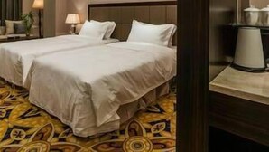 A hotel room with two beds, a large mirror, and a coffee maker on a side table. - Fujian Enjoy Hotel (Fuzhou)