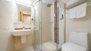A modern bathroom with a glass-enclosed shower, a white sink, and a toilet. - Sunkist International Hotel (Shanghai)