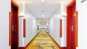 A long, narrow hotel corridor with red doors on either side and a carpeted floor. - Sunkist International Hotel (Shanghai)