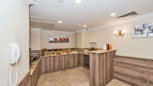 A modern kitchen with wooden cabinets, a marble countertop, and a fruit display. - Alphonse Hotel (Istanbul)