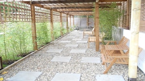 A covered outdoor seating area with wooden benches and a pergola structure.