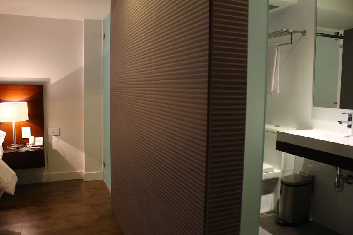 A modern bathroom with a sink, mirror, and toilet.