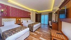 Habitación de hotel con dos camas, televisión, escritorio y una silla.