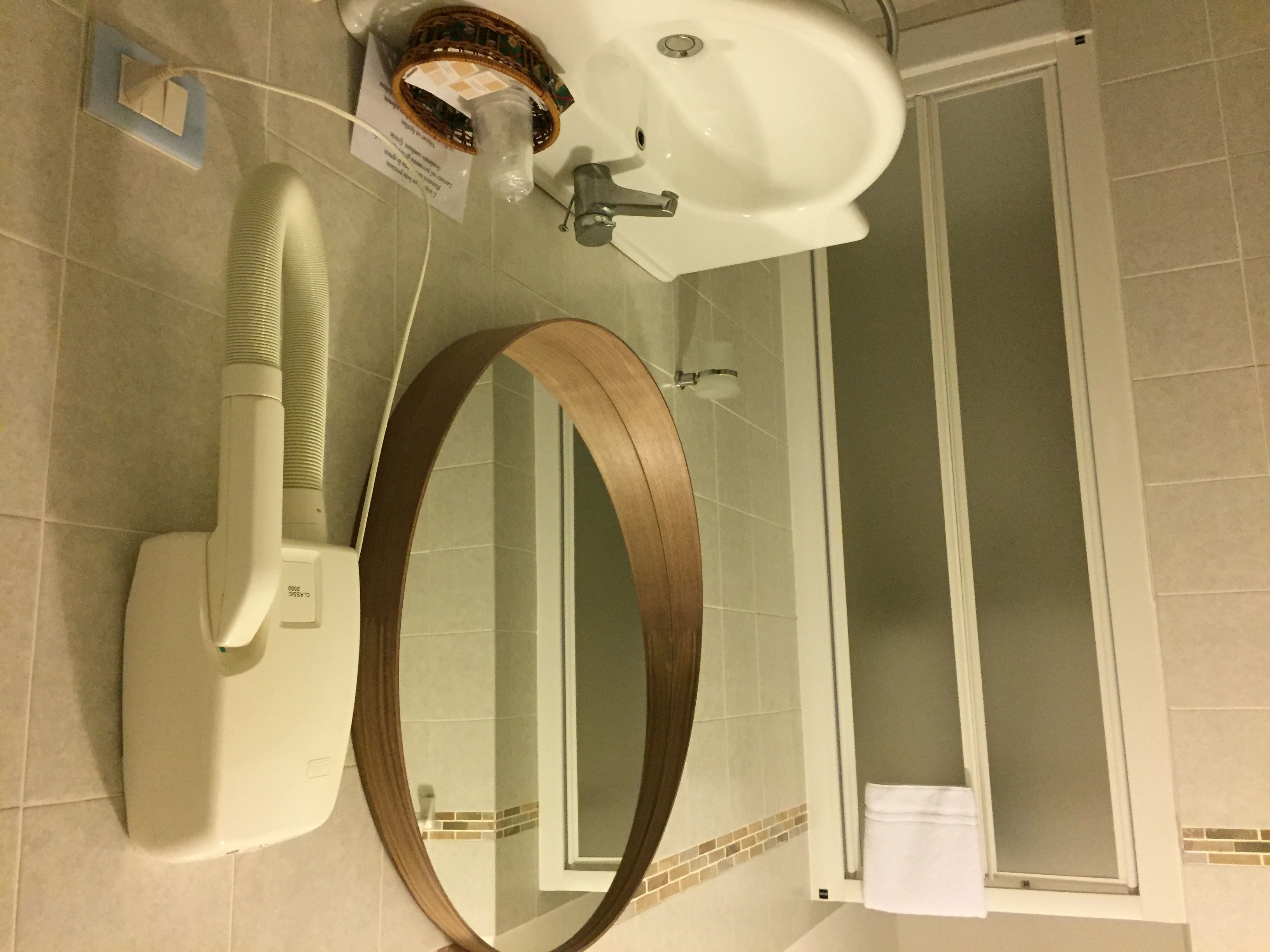 A bathroom with a toilet, a bidet, a mirror, and a shower area.