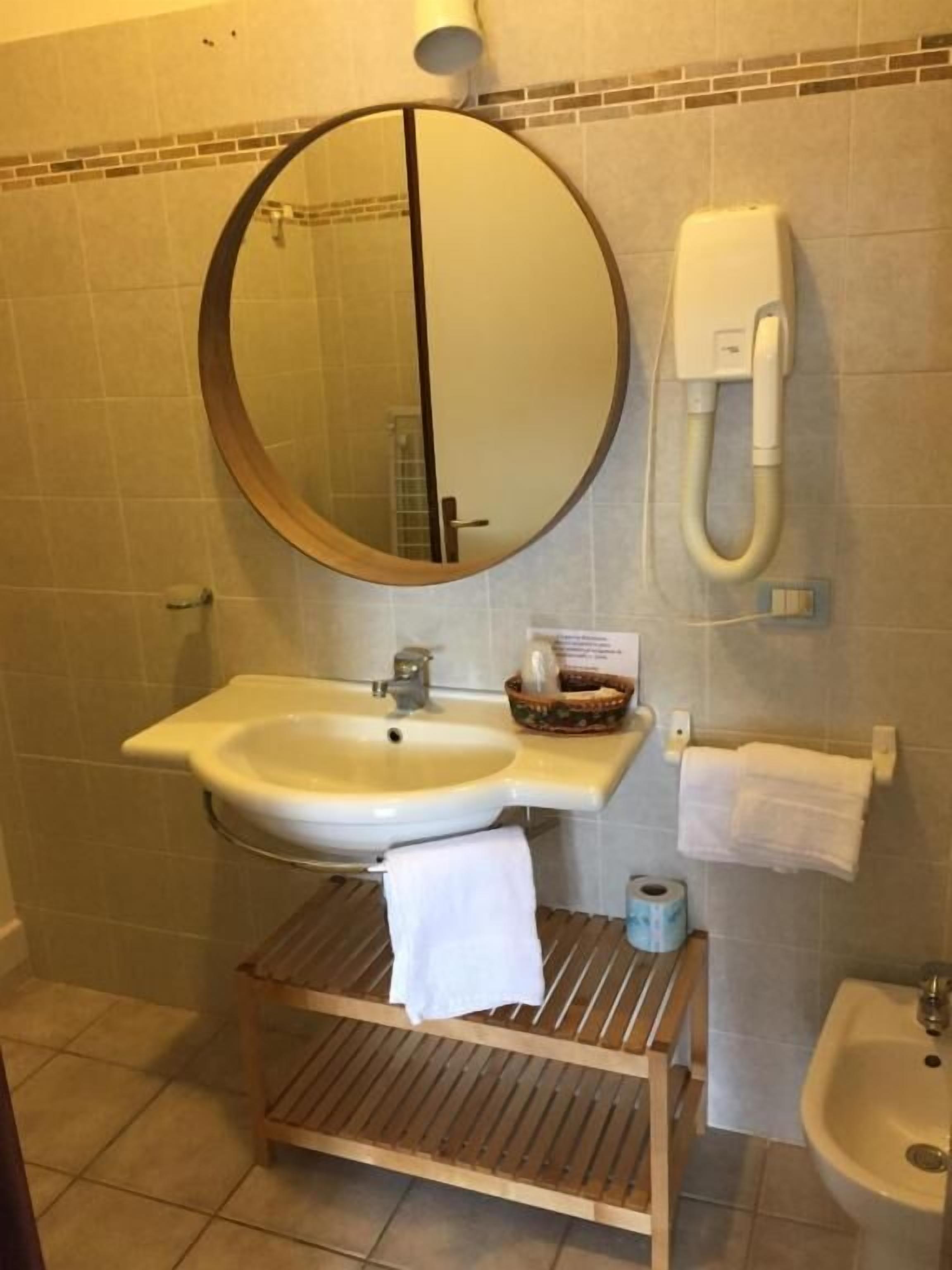 Une salle de bain équipée d’un lavabo, d’un miroir et d’un bidet.
