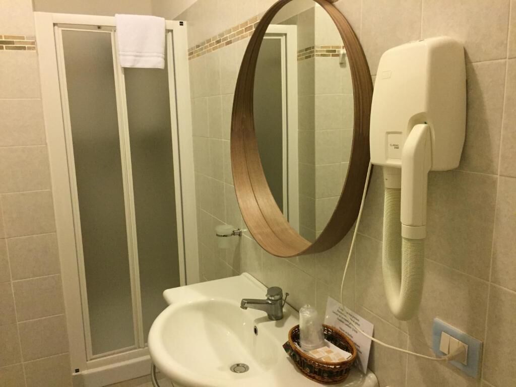 Une salle de bain équipée d’un lavabo, d’un miroir et d’une douchette à main.