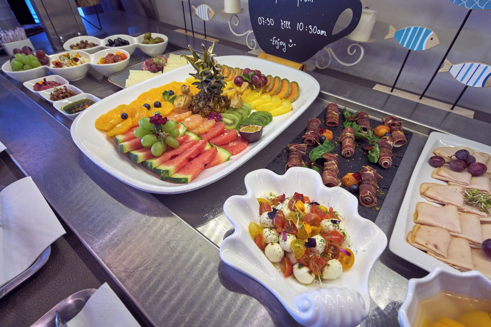 Buffet com diversos alimentos, incluindo frutas, vegetais e carnes.