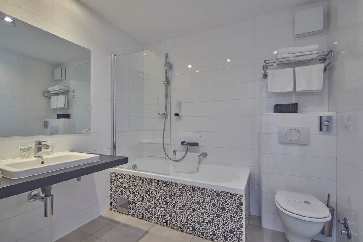 A modern bathroom with a glass-enclosed shower, a freestanding bathtub, a toilet, and a vanity with a sink.