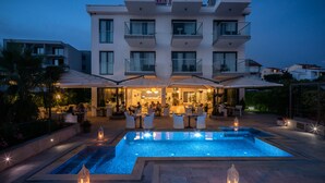A modern hotel with a swimming pool, outdoor seating, and a bar area. - Boutique Hotel Life (Rogoznica)