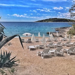 Sulla spiaggia, sabbia bianca, lettini da mare, ombrelloni