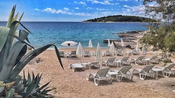 Di pantai, pasir putih, kerusi lepak pantai, payung