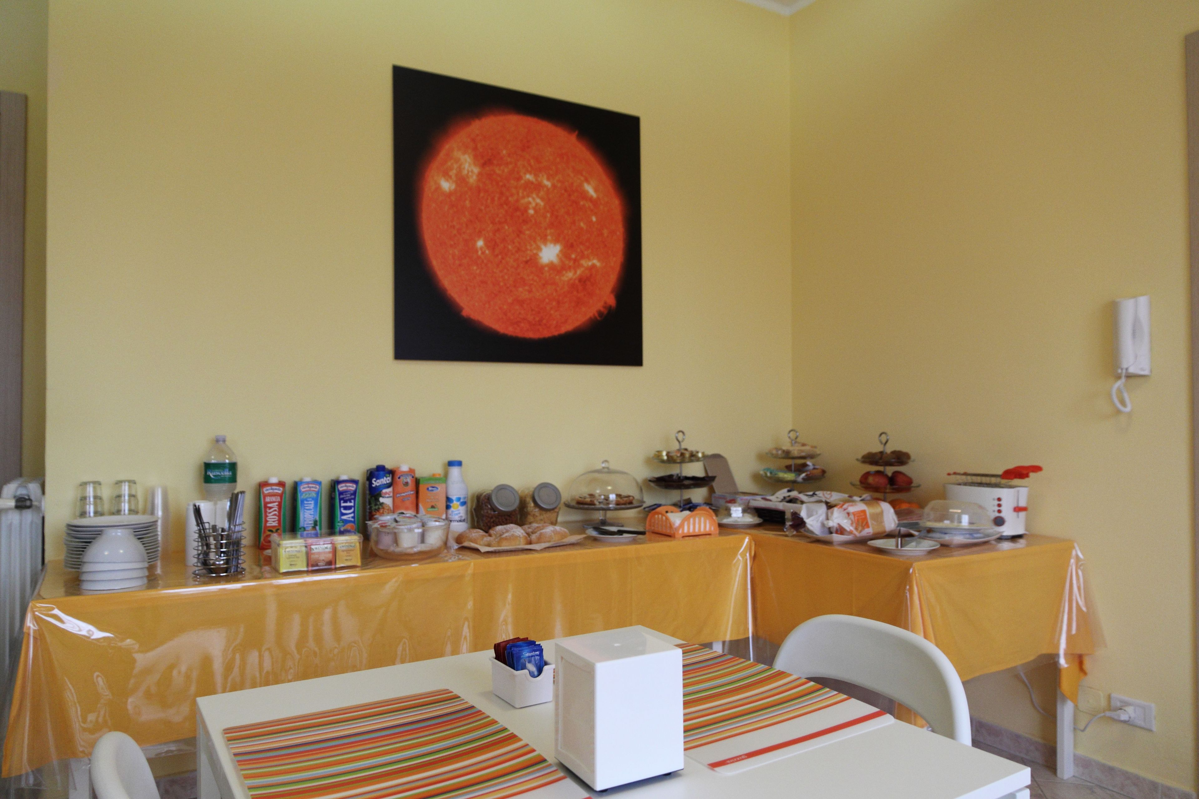 A dining area with a table set for breakfast, featuring a variety of food items and a coffee machine.