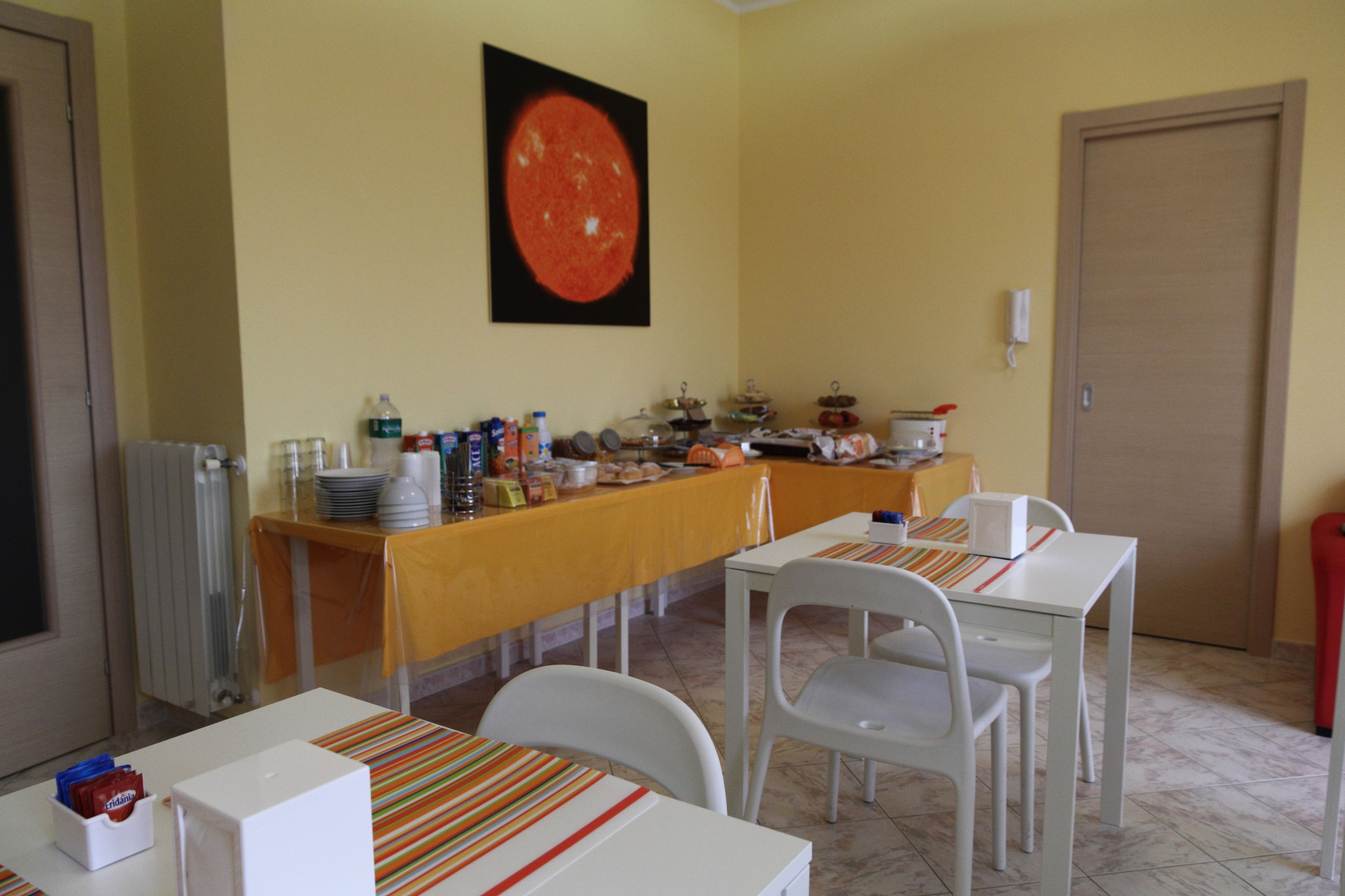 Zona pranzo con buffet, comprendente un tavolo con sedie, un'area buffet con cibi e una fotografia appesa al muro.