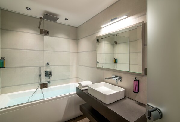 A modern bathroom with a glass-enclosed shower, a white sink, and a large mirror. - Summer Dream (Rethymno)